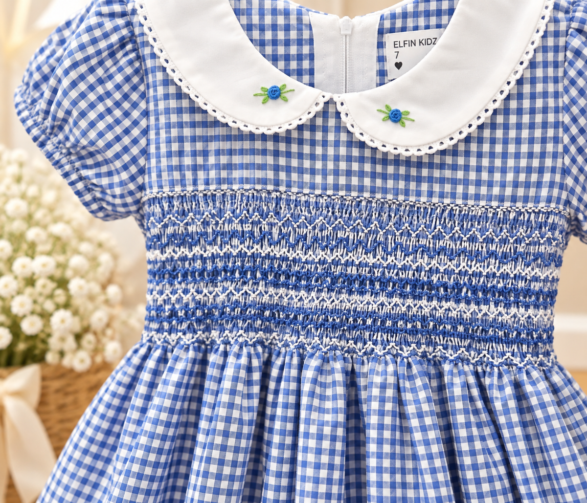 Close-up of blue gingham hand-smocked girls dress with embroidered Peter Pan collar and detailed smocking